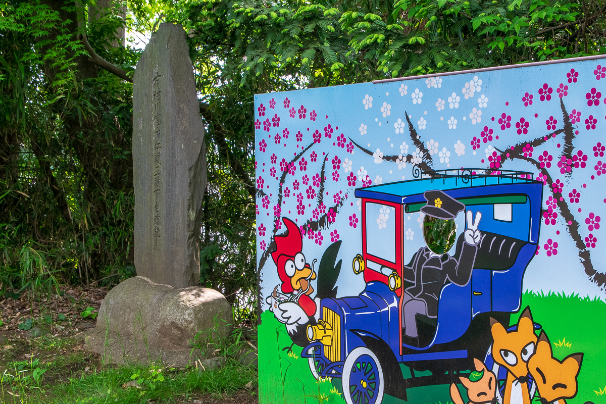 梅林の昼食会が開かれた場所に建立された有栖川宮の碑とタクリー号の顔ハメ看板