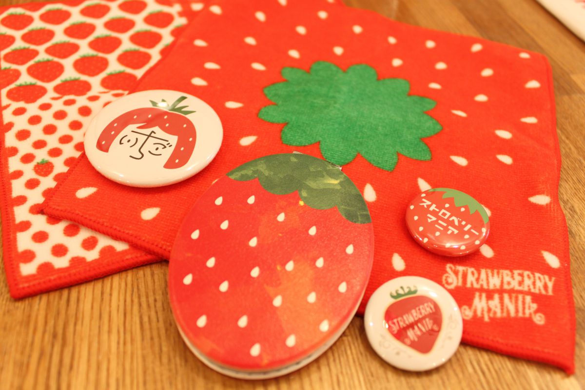 いちごミラー 950円、缶バッジ（小100円・大300円）、今治いちごタオルハンカチ 950円