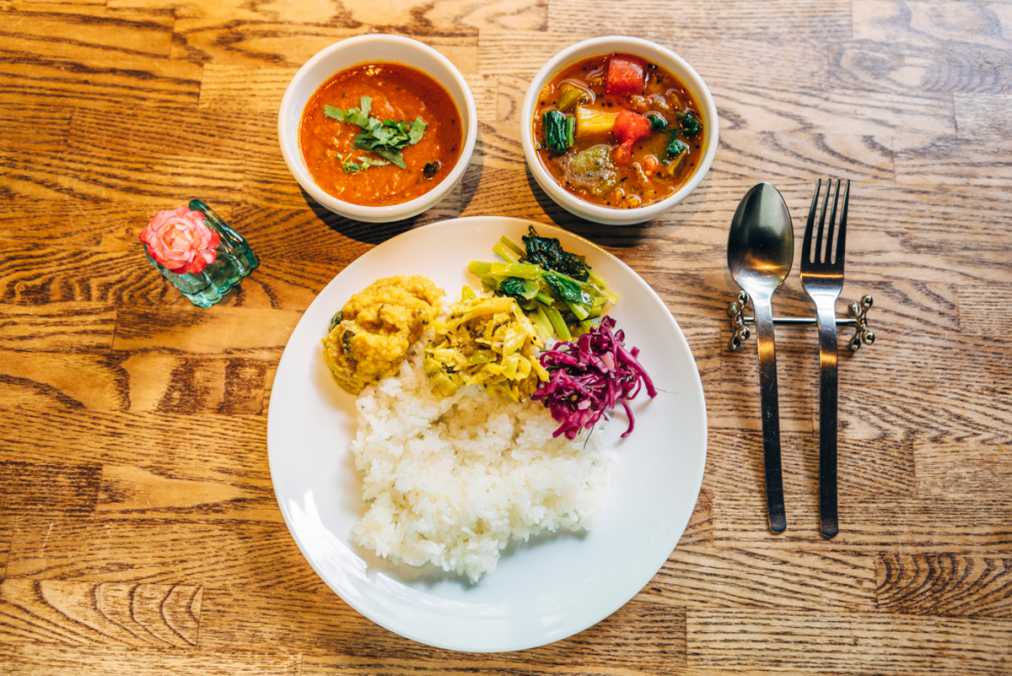 デザートとコーヒーが付くペアカレーランチ1400円。左がラッサム、右が南インドの家庭料理であるナスとピーマンのサンバル。ご飯の上にのっているおかずは日替わり