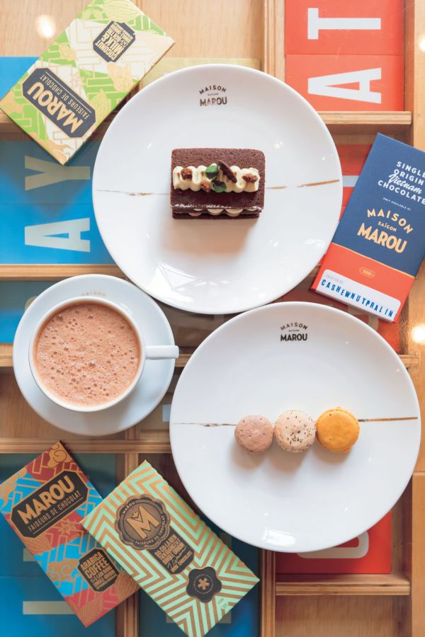 ソファ席のガラステーブルに商品を並べて真上から撮影すると、こんなに可愛く撮れちゃいます！ミントチョコレートケーキ12万VND、シグナチャー・ココア9万VND、マカロン2万5000VND（1個）