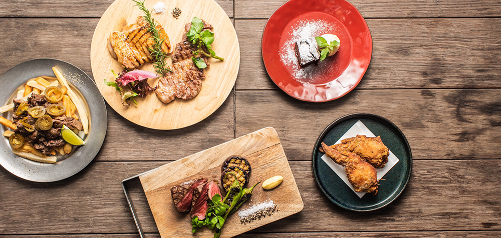 上から時計回りに「大山鶏のハーブグリル」1400円、「ハーブ三元豚肩ロースのグリル」1600円「ガトーショコラ」500円、「KAGUAの為のフライドチキン」1piece/400円、「尾崎牛のグリル」150g/4000円〜、「フライドポテト ビーフハラペーニョ」800円(すべて税込)