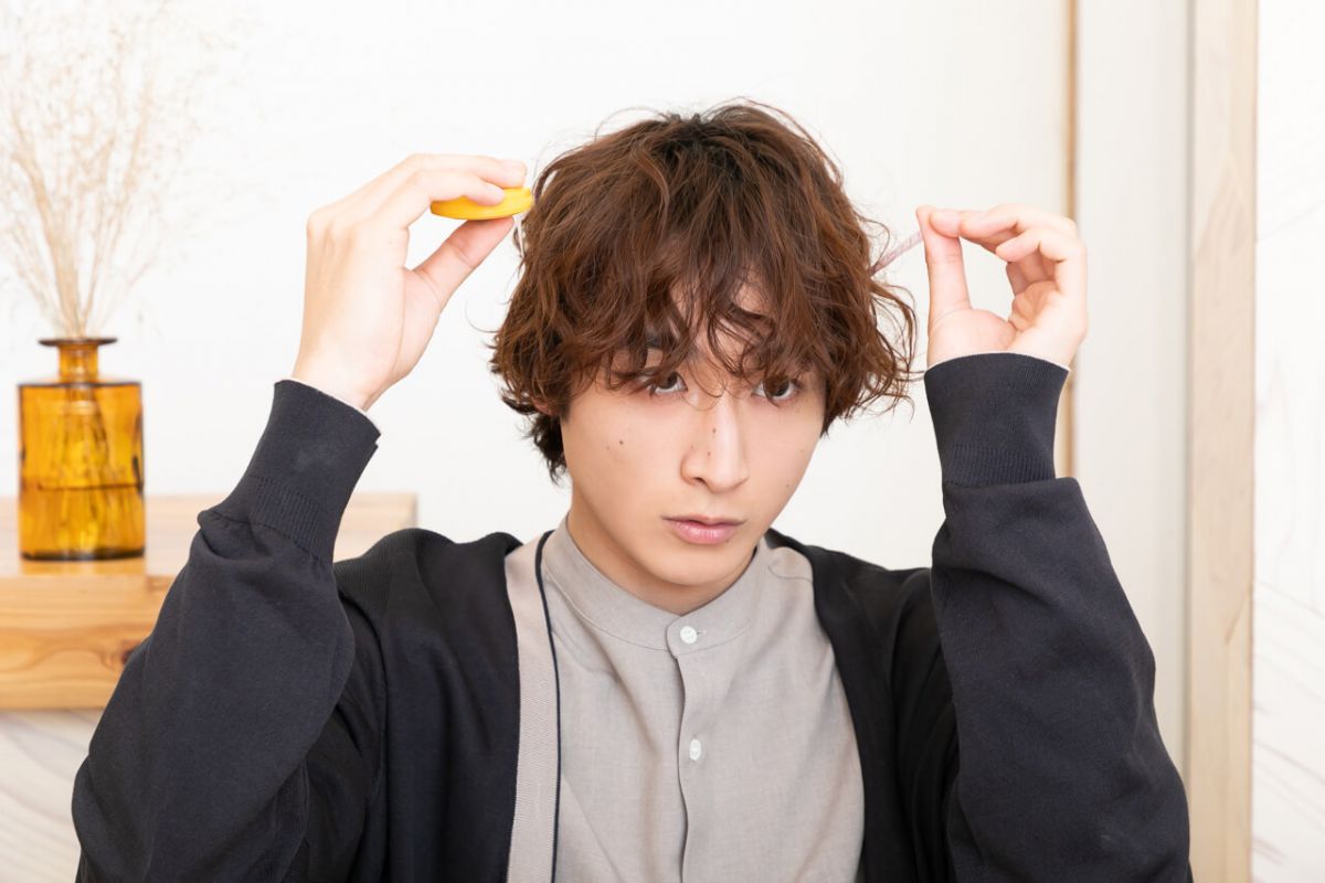 帽子の頭のサイズを測る小関さん