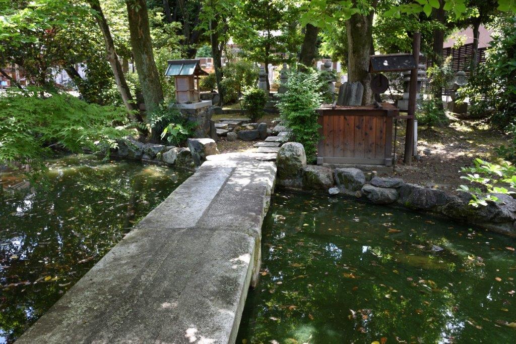 本堂前の池は小町が姿を映したという「小町姿見の池」。石橋を渡った右側には少将ゆかりの井戸「涙の水」がある