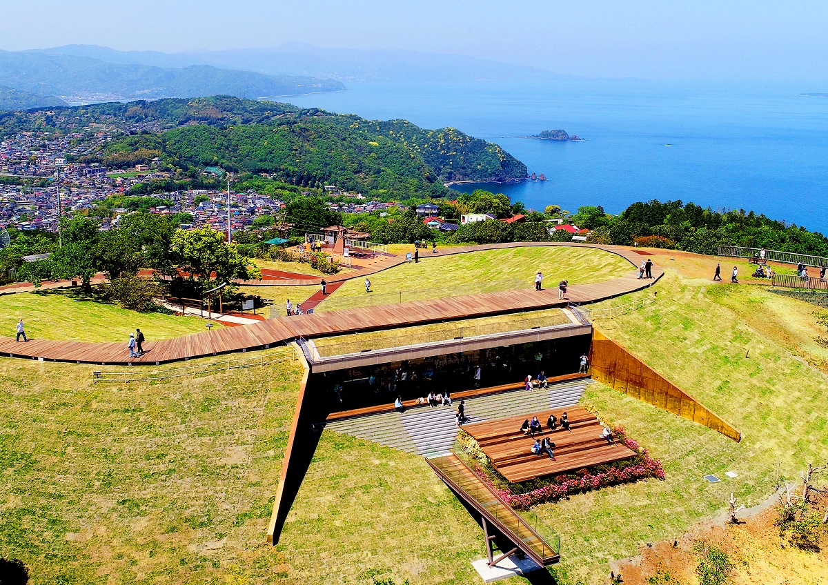 地中に潜り込んでいるような造りのカフェ。カフェの上には山の稜線に沿って設置されたボードウォークが