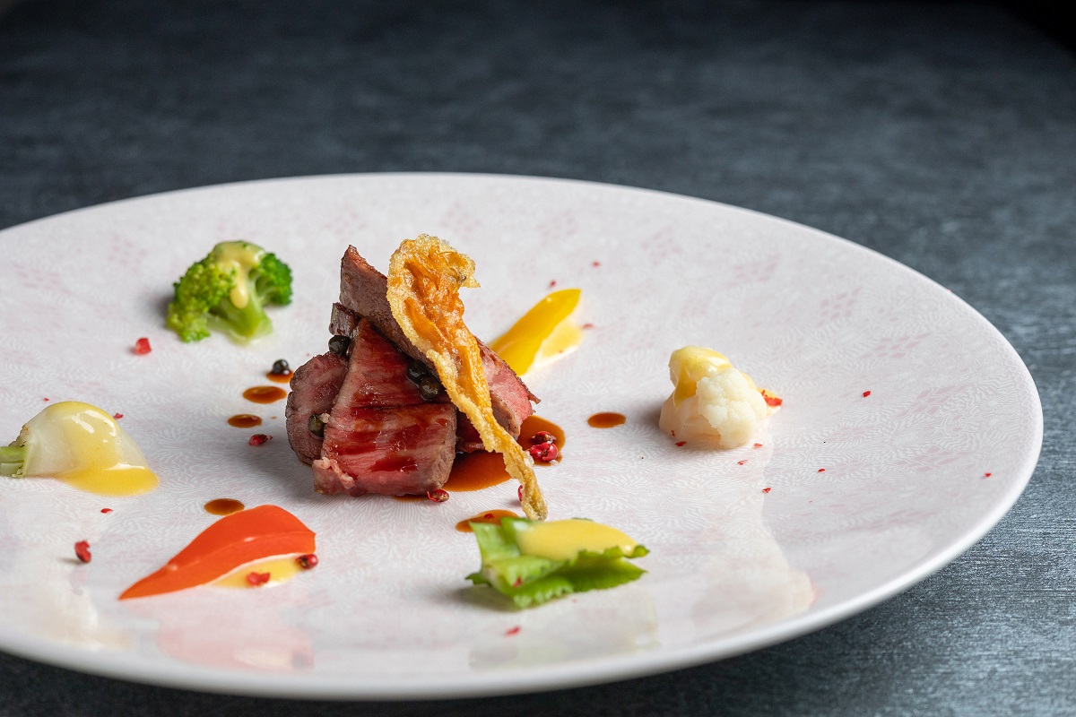 ディナーのメイン。和牛フィレのロティ、温野菜のアイヨリ、クワン草のビール揚げがひと皿に