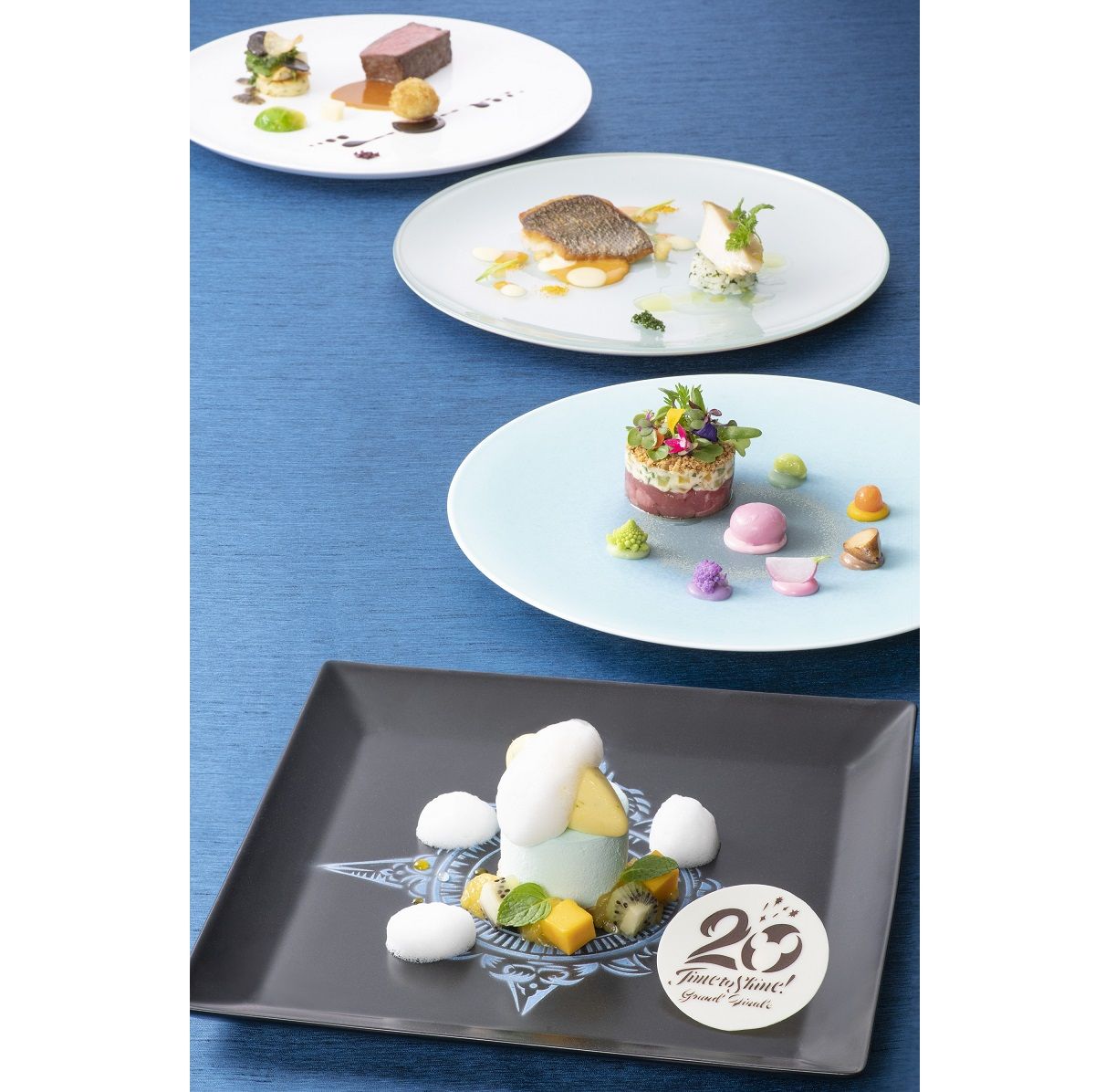 「東京ディズニーシー20周年：タイム・トゥ・ シャイン！」グランドフィナーレ「グルメディナーコース」 ■オマール海老のマリネ ホワイトアスパラガスとトマト プロシュートと無花果のブリオッシュ ■鮪のサラダと帆立貝のムース ■ホロホロ鳥のポワレ オゼイユとルッコラ ■イサキのソテーと鮑 クリュスタッセのエミュリュションとエピス ■和牛サーロインのロースト トリュフとポテト 　または 　白金豚のローストと肩肉のブレゼ トウモロコシのピュレ ■パイナップルソテーとトロピカルフルーツクリームのココナッツムース ライム香るパイナップルのソルベ ■プティ・フール ■コーヒー または 紅茶