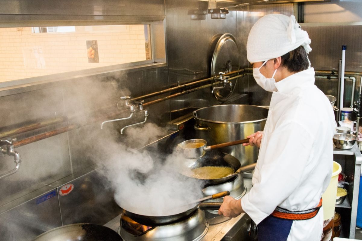 鮮やかな手さばきで鍋を振るう