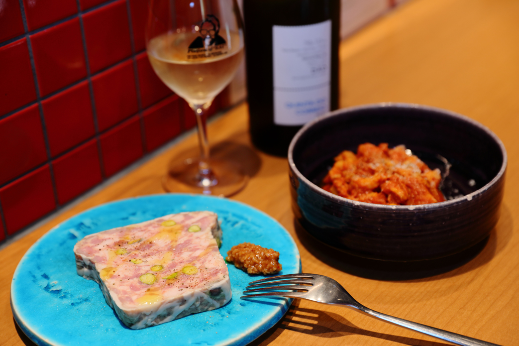 軽く燻製したもち豚のパテ1000円（左）、トリッパのトマト煮込み1100円、ナチュラルグラスワイン（グラス）580円～
