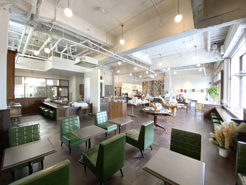 木目とグリーンが調和した落ち着いた雰囲気の喫茶スペースにはカウンター席とテーブル席が用意され、ゆったりと寛げる