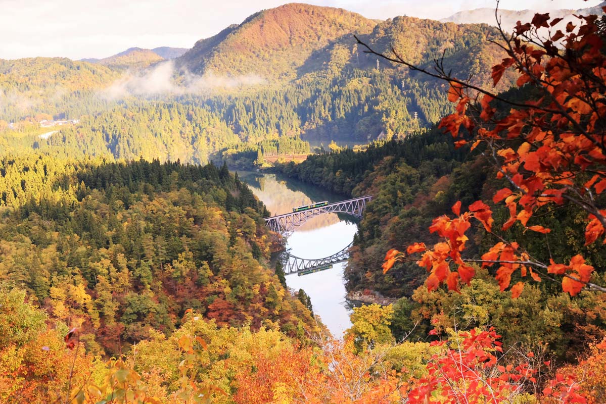 秋の紅葉で色づく山々を背景にした「第一只見川橋梁」（撮影：奥会津郷土写真家　星賢孝）