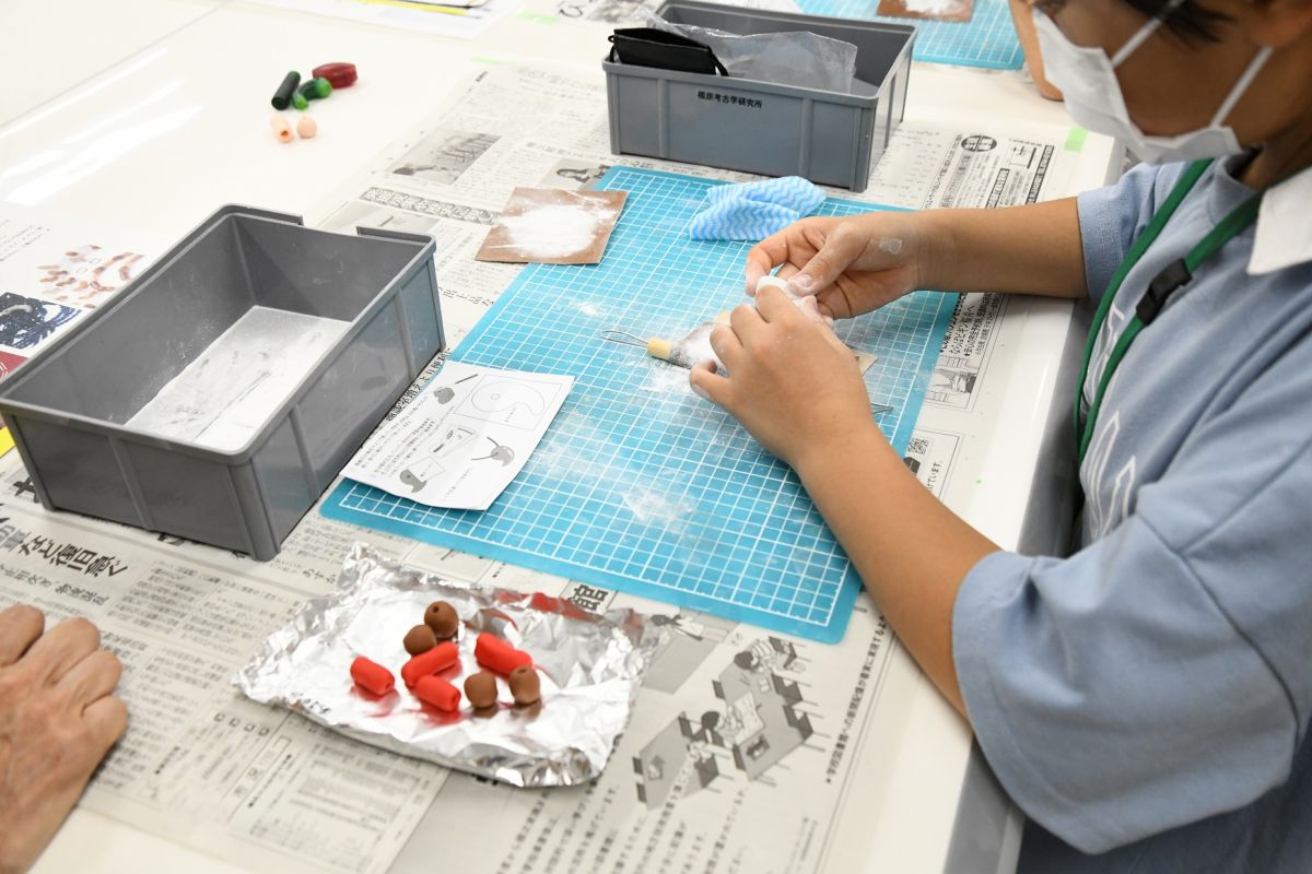 考古遺物修復工房のワークショップ「古墳時代のレガリア装着と勾玉作り体験」の様子