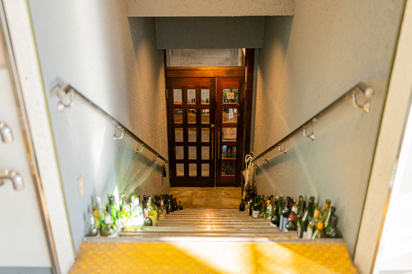 改札口側にある、専用階段とつながる入り口は、階段の両側に置かれたワインボトルがランドマーク