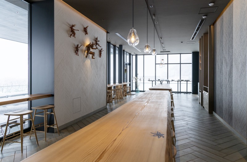 樹齢200年の美山杉で仕立てた一枚板のテーブルが置かれた店内。九頭竜川と永平寺の里山の風景を眺めながら食事が楽しめます