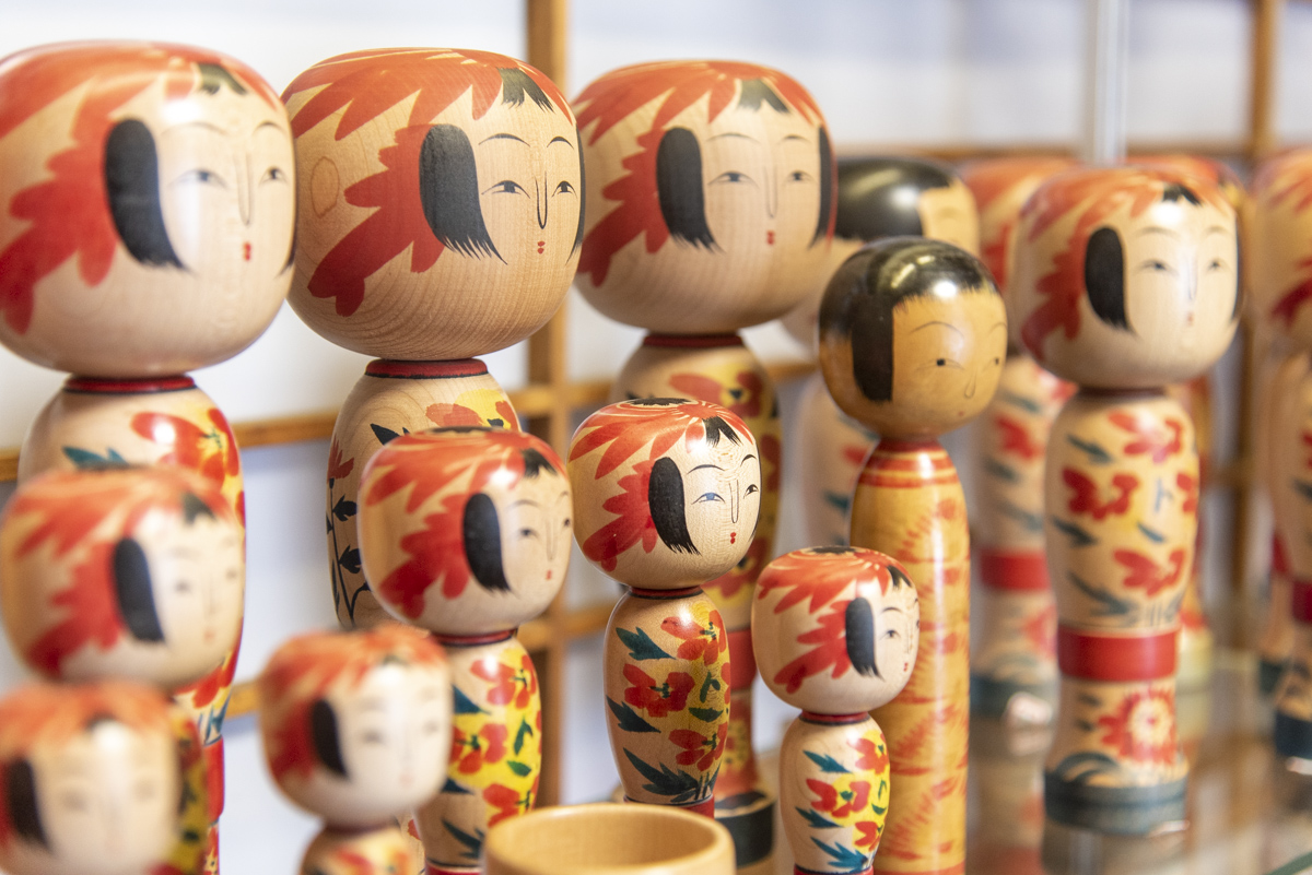 伝統こけしは、菊や紅花など山形を代表する花が描かれる。ヘアスタイルはおかっぱが多く、ウエストがくびれたグラマラスなスタイルも特徴。6寸2800円～