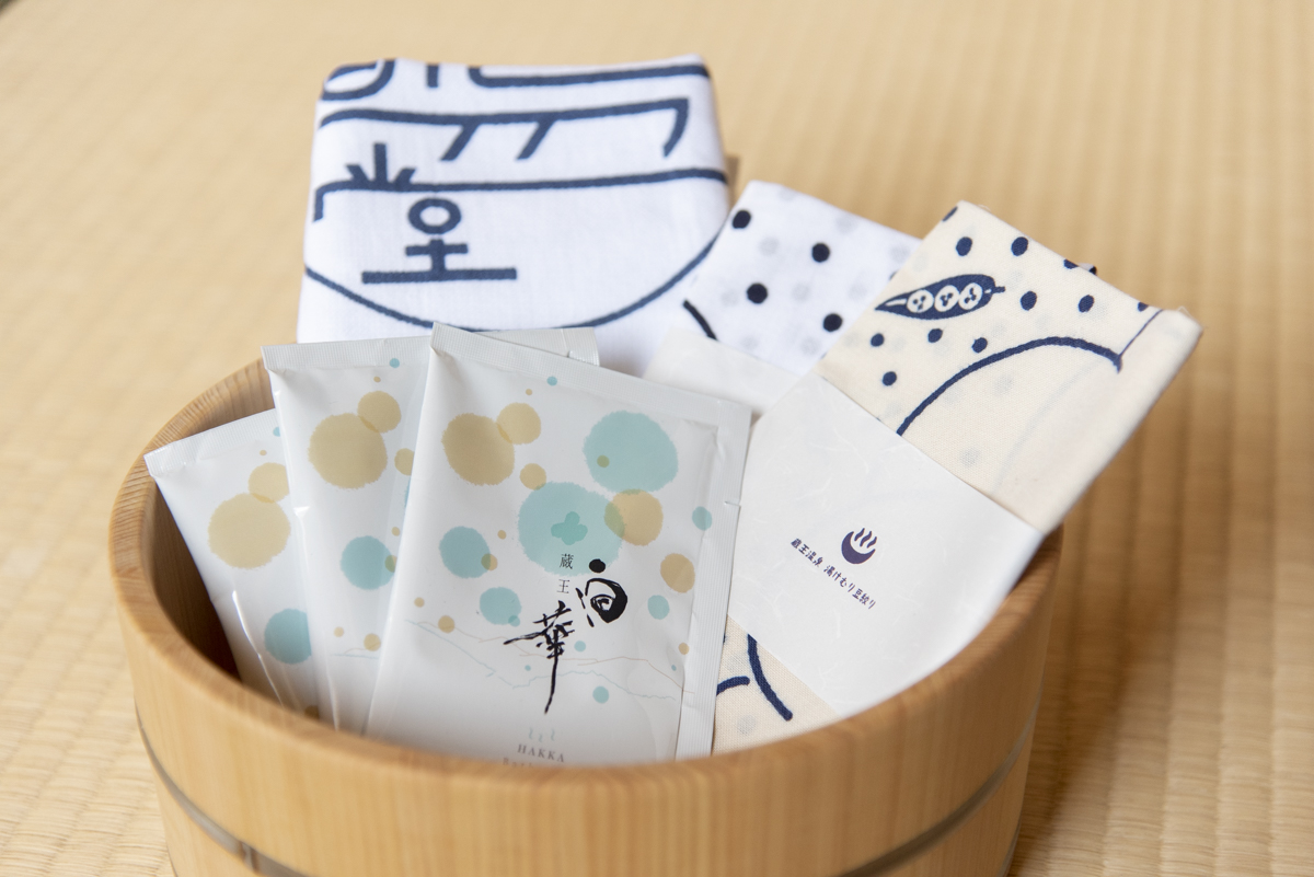 湯めぐり豆絞り手拭い1126円、高湯堂オリジナル絵柄のタオル1126円（2枚セット）入浴剤1袋220円