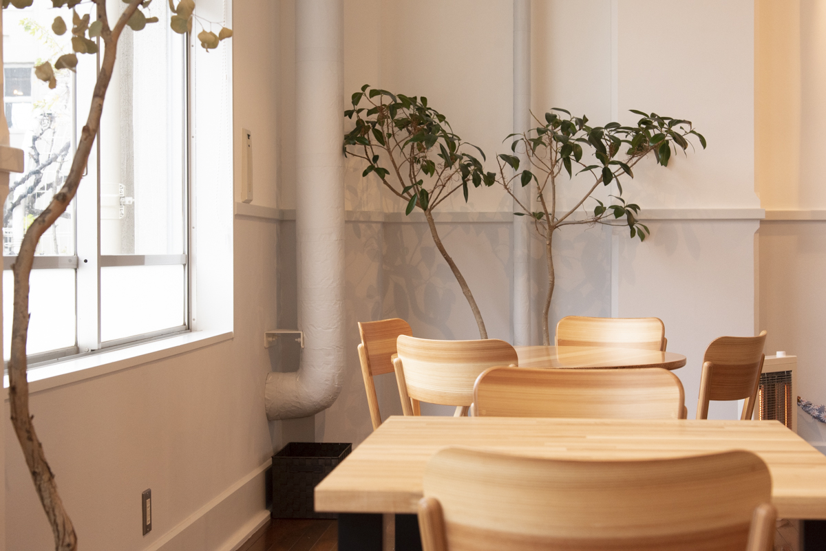 山形の木材を活かしたテーブルや椅子、パリのアンティークなポスターなど、内装も異なるものの出会いのハーモニー