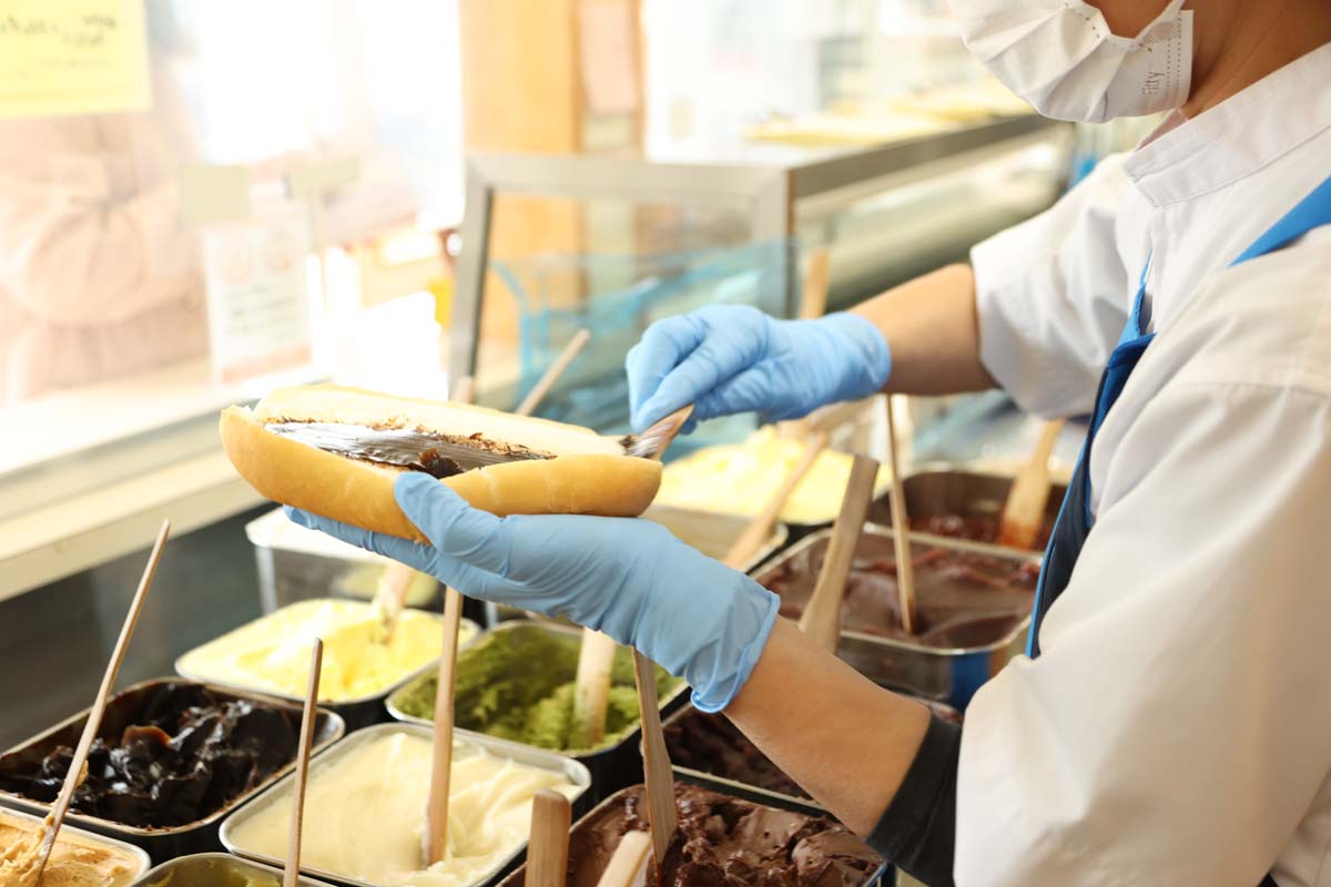 注文を受け、コッペパンの両面に職人さんがたっぷりと塗ってくれる