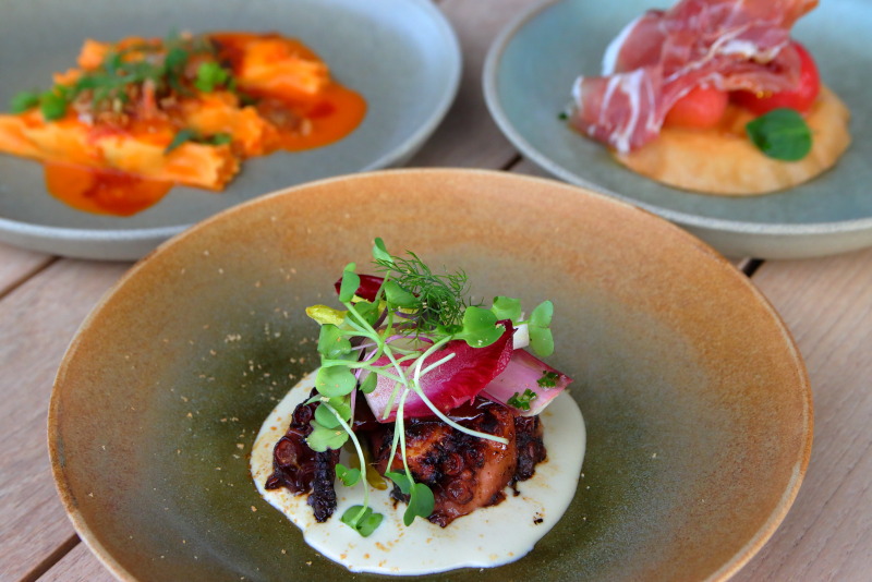プリフィックスコースの前菜。炭火で焼いたタコ（中央）、キングクラブのパスタ（左上）、チェリートマトのタルト（右上）