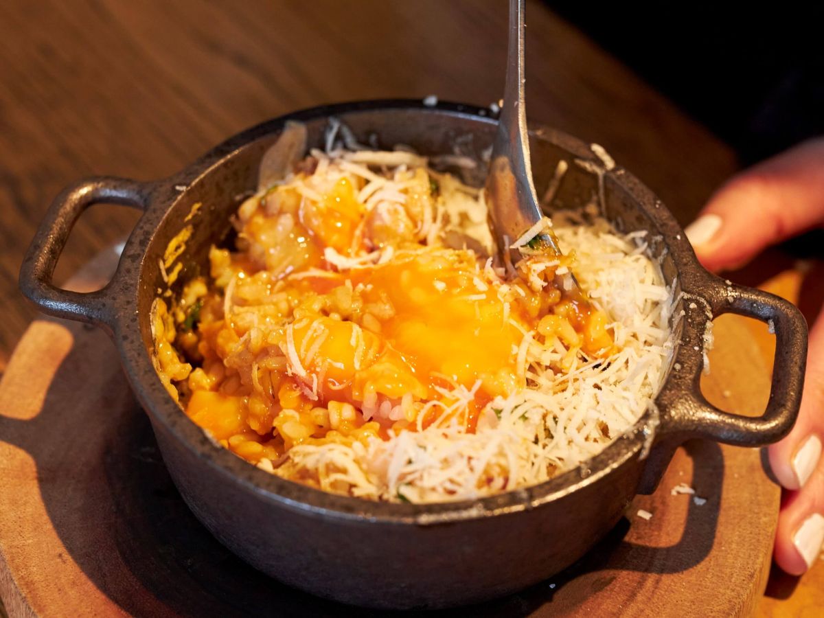 熱々の器の中で押し麦、卵黄、エビ、削りチーズをまぜまぜ♪