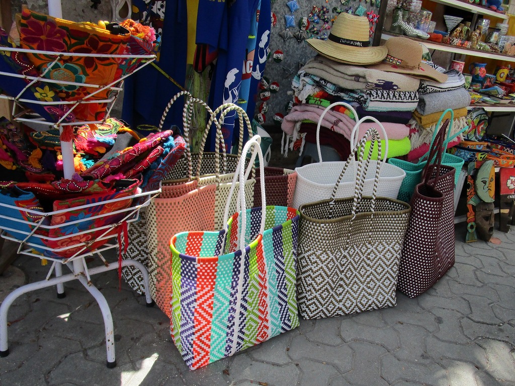 カラフルでかわいいビニール製の編み込みバッグが並んでいた店