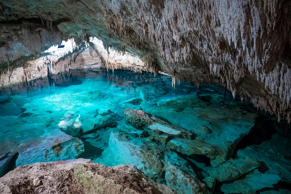 洞窟に射し込む光を浴びて、その透明な姿を見せる神秘の泉／写真／仁尾たてわき