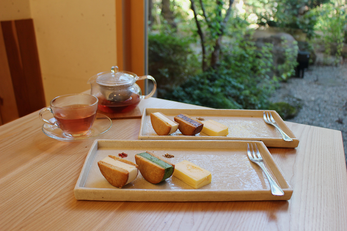 写真手前がプレーンと抹茶のチーズバターサンドのセット、写真奥がプレーンとチョコレートのチーズバターサンドのセットの「テリーヌとサンド食べ比べ」※写真は2名分。（写真左奥）「飛騨の野草（HOT）」550円
