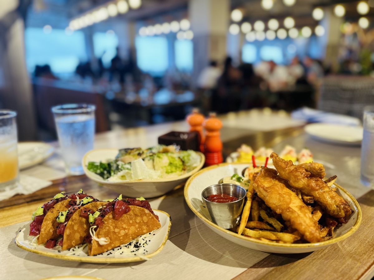 左側のポケタコス（25ドル）、左奥のシーザーサラダ（16ドル）、右奥のロブスター・デビルド・エッグ（23ドル）、右側のシェフ・ピーター・メリマンのフィッシュ・アンド・チップス（26ドル）