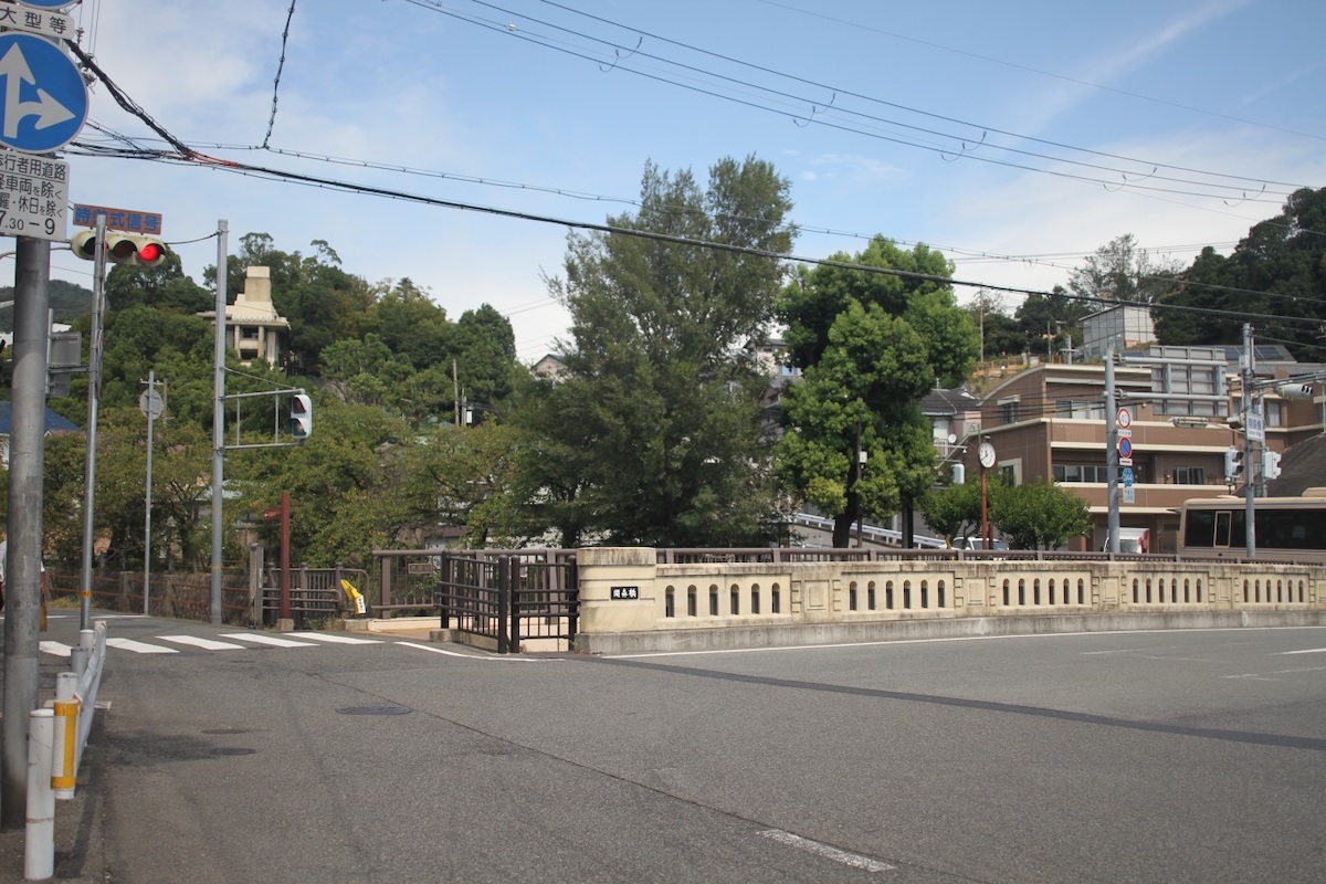 開森橋の奥、左側の森を背に立つ白っぽい特徴的な建物が「ヨドコウ迎賓館」