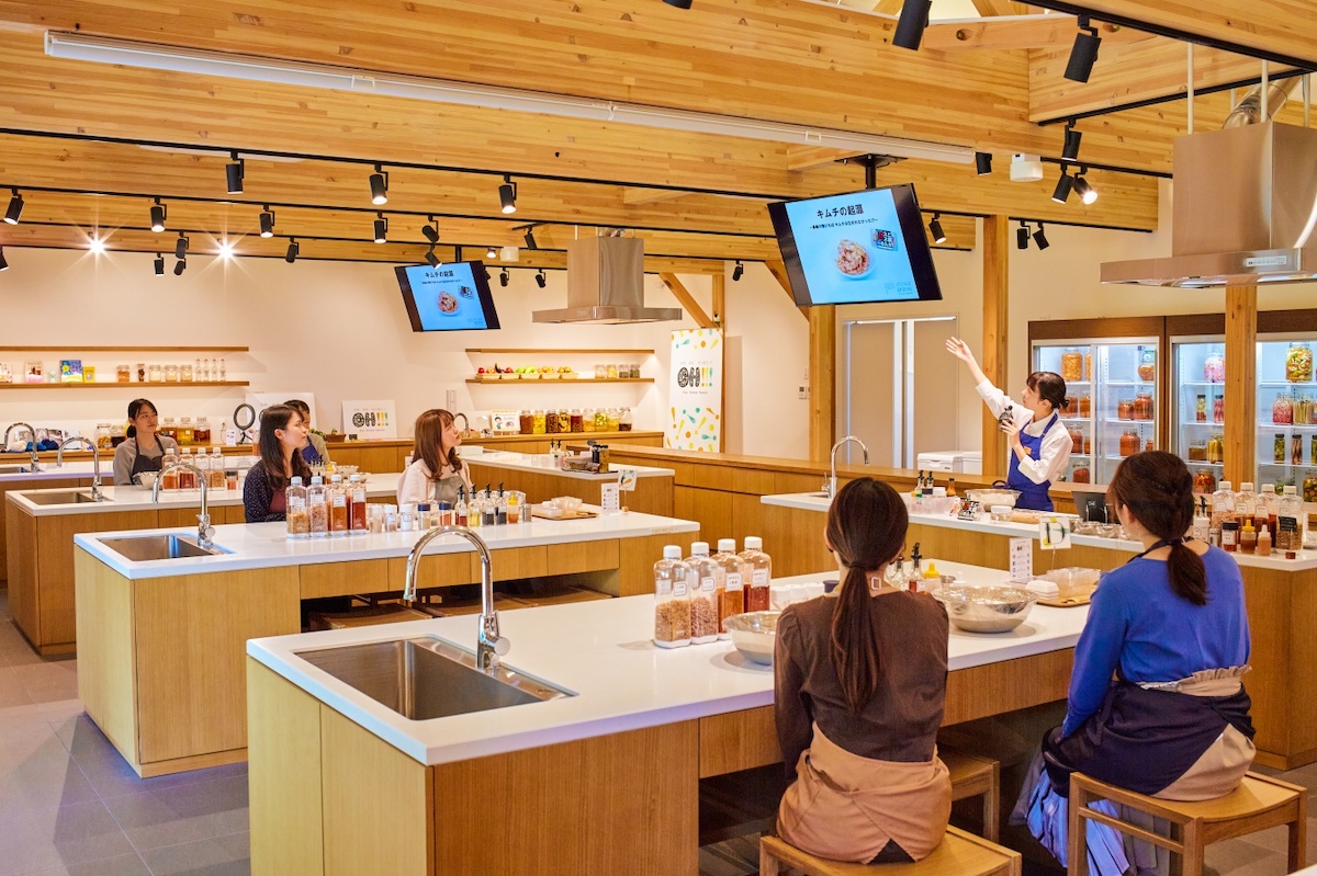 キムチの歴史や「ご飯がススムキムチ」の開発秘話などの解説を受ける