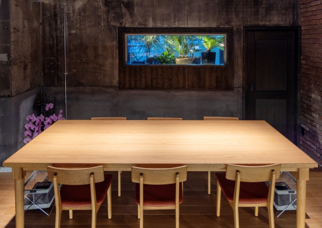 店の奥にある6人掛けのテーブル席。夜は背後の窓が水槽のように見えます