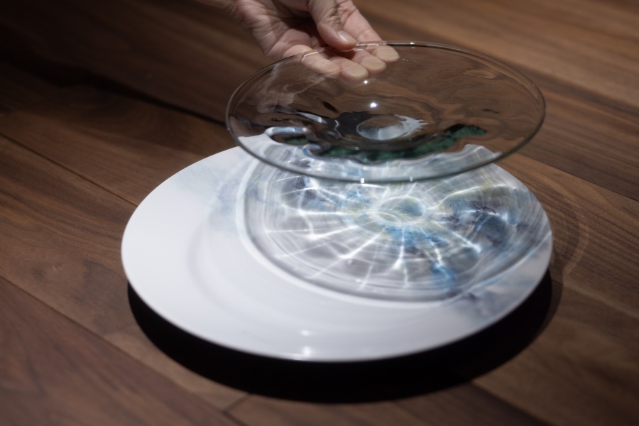 皿を置く瞬間の影の美しさも素敵。下のショープレートの図柄は地元の女性画家が1枚1手描きで仕上げています