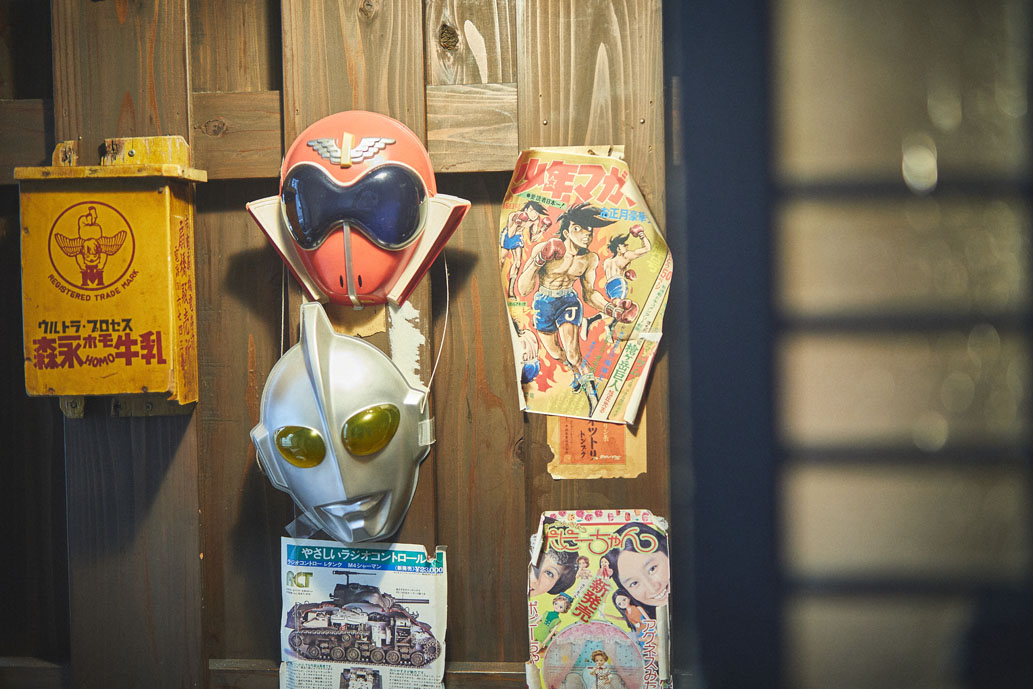ヒーローのお面や昭和マンガの表紙などが飾られる