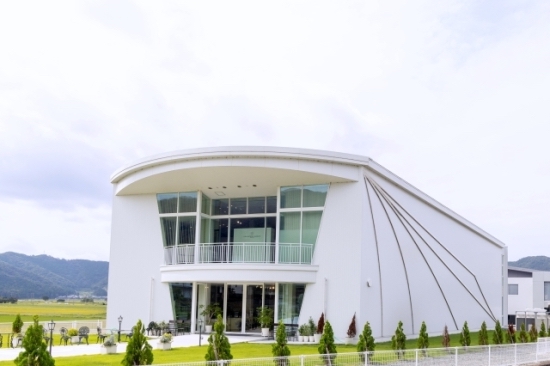 翼をイメージしたLEDラインの装飾を施した白い建物が目印