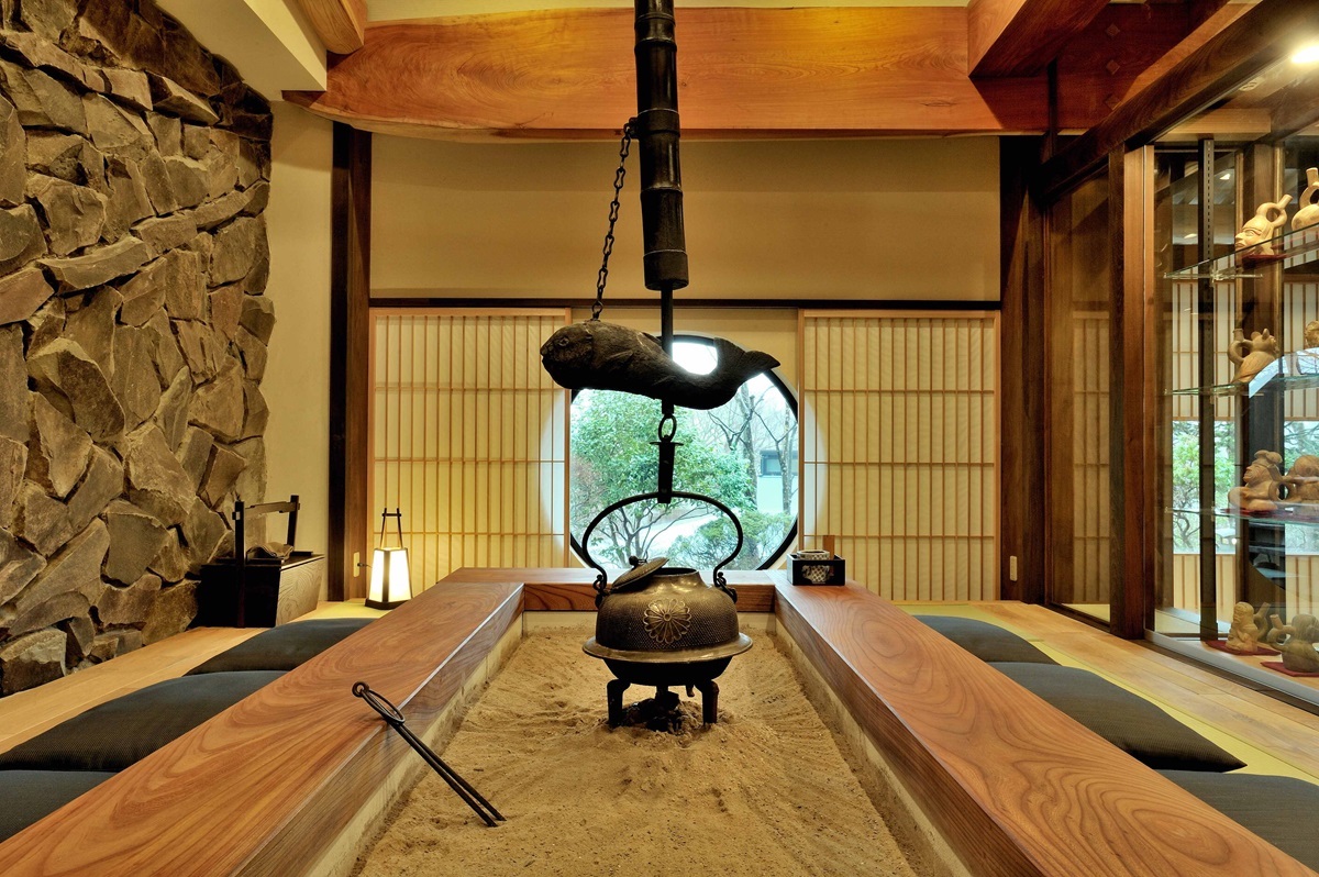 1階の囲炉裏。一枚板の框、魚のような形の横木など木のぬくもりに満たされている