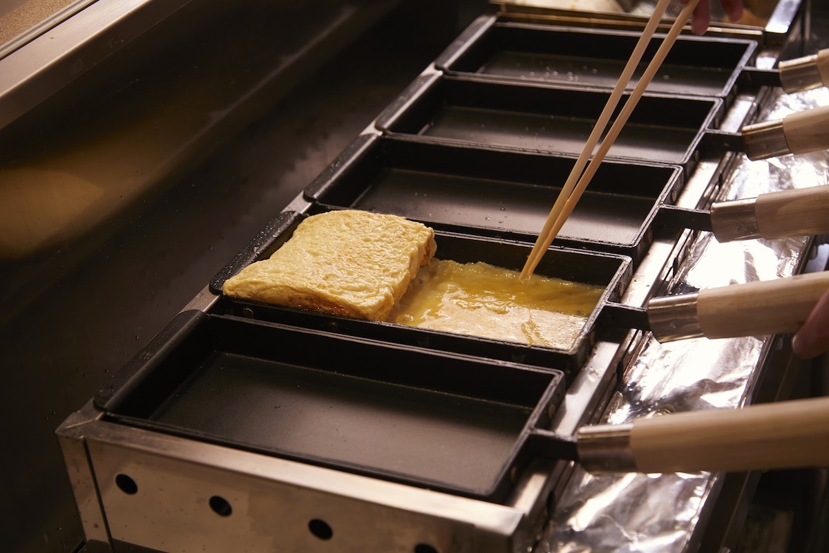 だし巻きたまごを巻いている様子／©️京都離宮