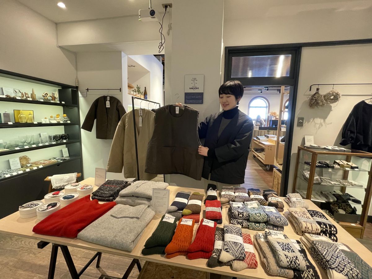 矢野さんが手にするのは「NAKASHI apron vest」1万7800円。着用中の「NAKASHI hanten jacket」2万3500円