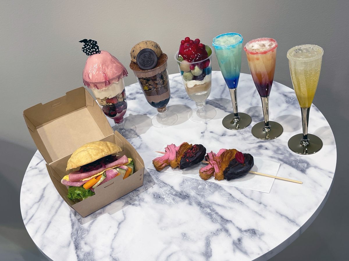 （左から時計回りに）「メロンパン サンドイッチ」1200円、「カシスとベリーのパフェ」1200円、「チョコレートとバナナキャラメルのパフェ」1200円、「白玉と季節のフルーツのパフェ」1200円、「ノンアルコール・ソーダモクテル（グレープフルーツ、ピーチ、パッションフルーツ）」各700円、「レターチュロス」1000円