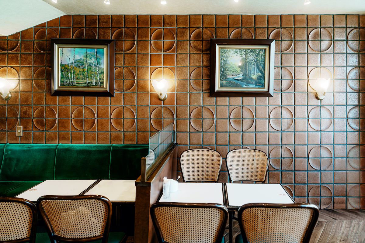 オレンジのタイルとグリーンのソファシートがレトロな雰囲気