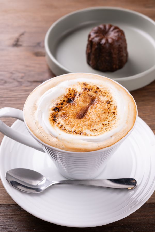 香り豊かなエスプレッソラテに生クリームと砂糖を浮かべ、表面を焼いて香ばしくした「ベイクド・ラテ・コンパナ」750円と、定番人気の自家製カヌレ400円