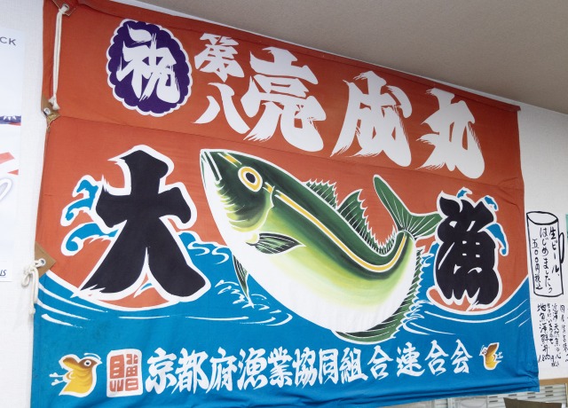 店内には大きな大漁旗が飾られ、市場内らしい活気のある雰囲気が漂います