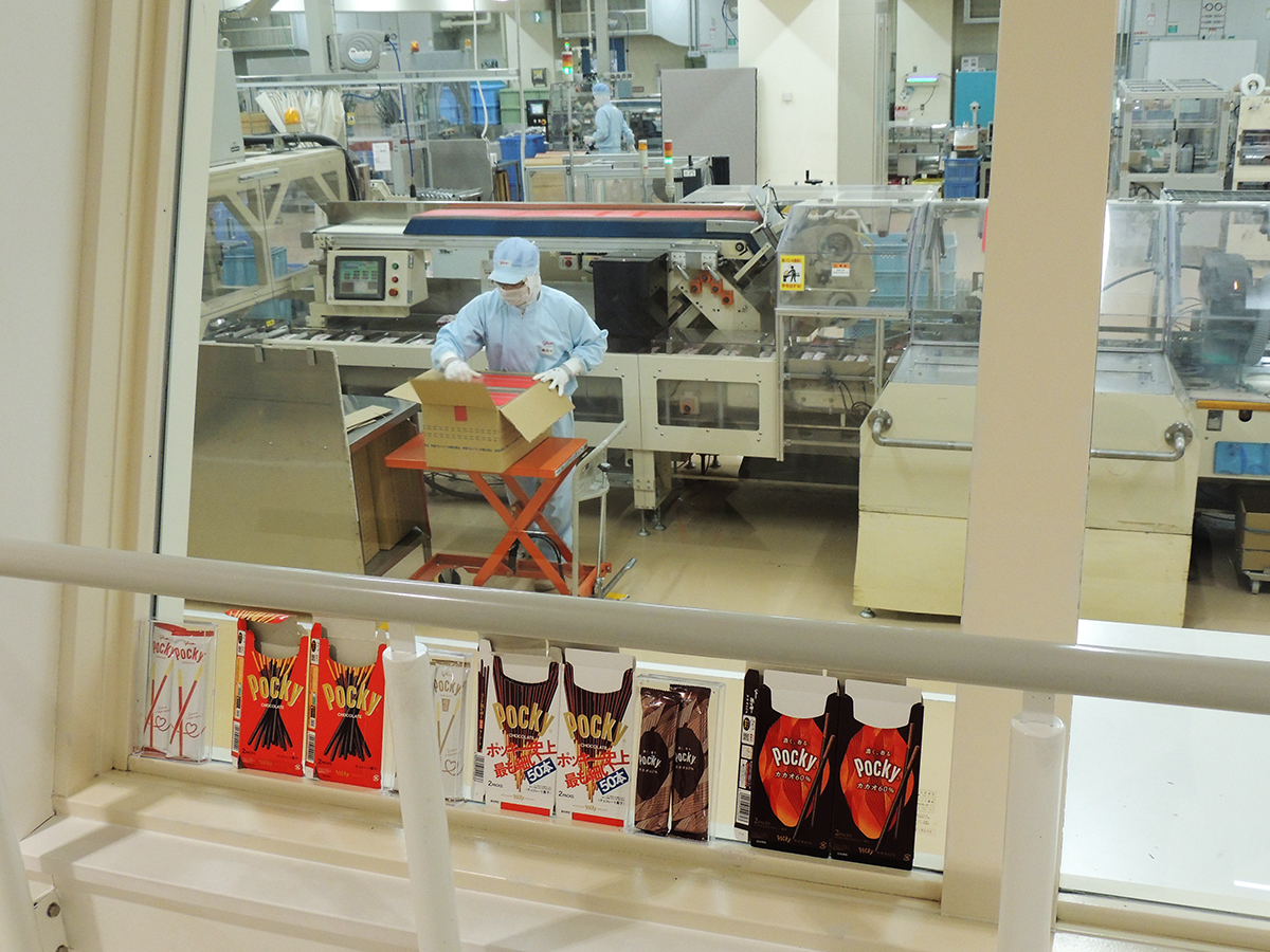 窓のところに置いてある箱にポッキーを詰めていく【3】箱詰め機