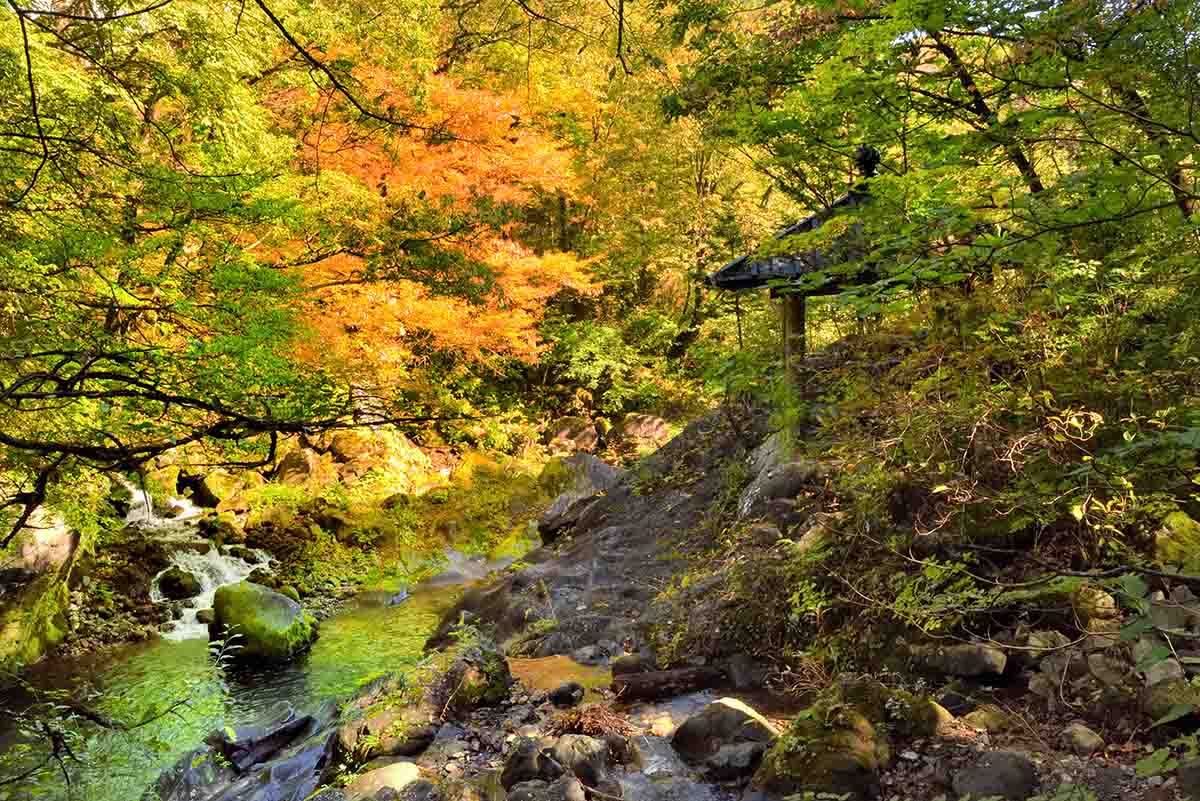 写真右側にあるお堂が霊庇閣。対岸上流の岩肌に「カンマン」の梵字がある