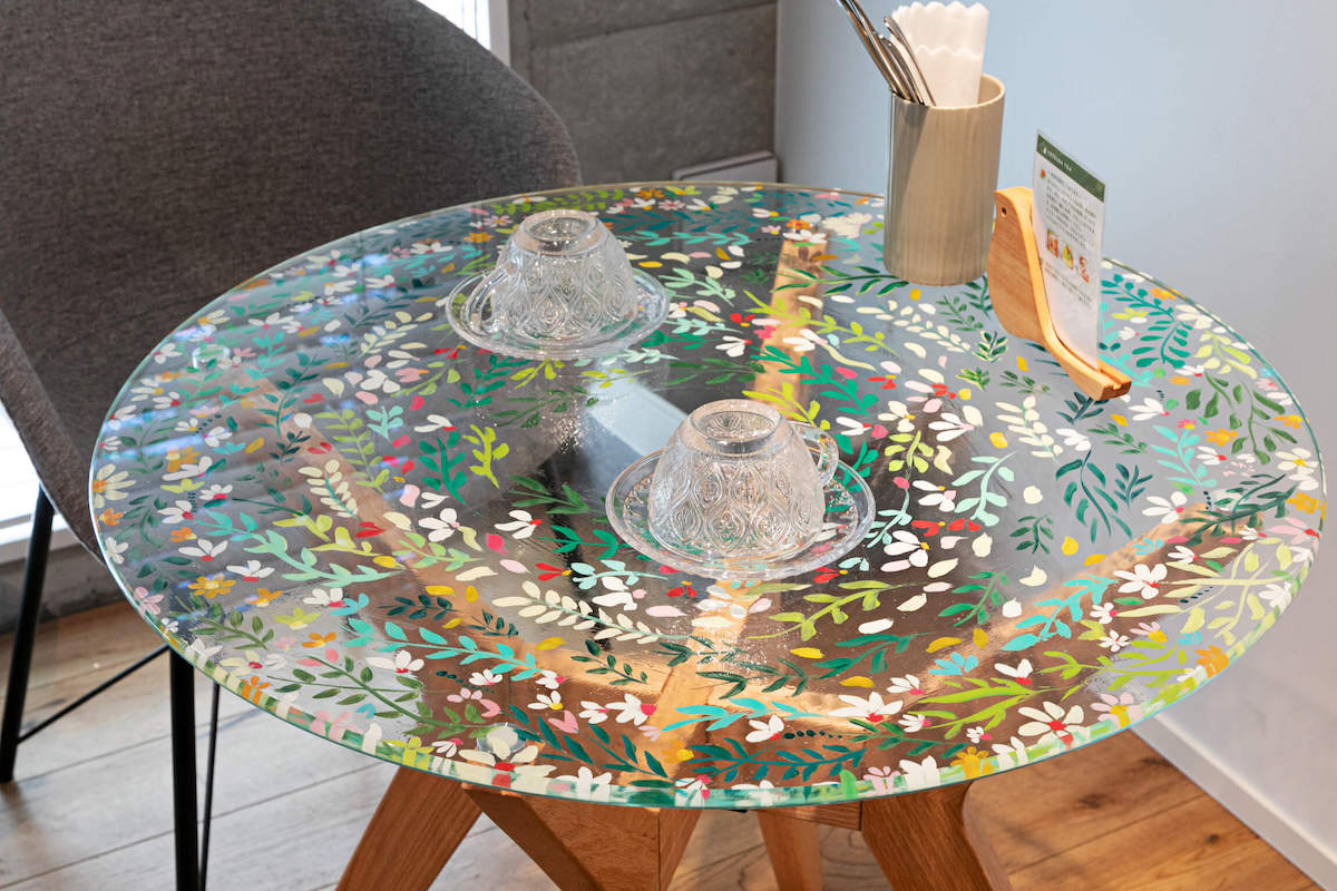 アーティストの倉中るなさんが手描きしたガラスのテーブル