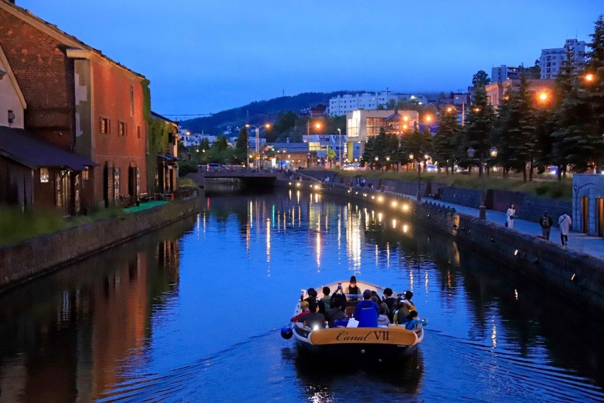 ガス灯のあかりが水面に映り、ロマンチックな雰囲気のナイトクルーズ。日没時間によって運航スケジュールが変わるのでホームページなどでチェックして／（Ｃ）小樽運河クルーズ