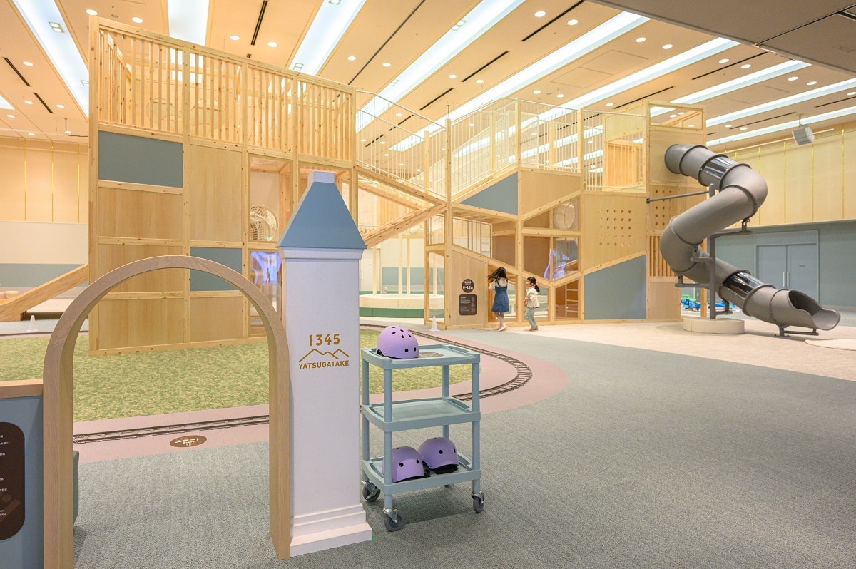 写真奥に見えるのは八ヶ岳をイメージした木製の大型立体遊具