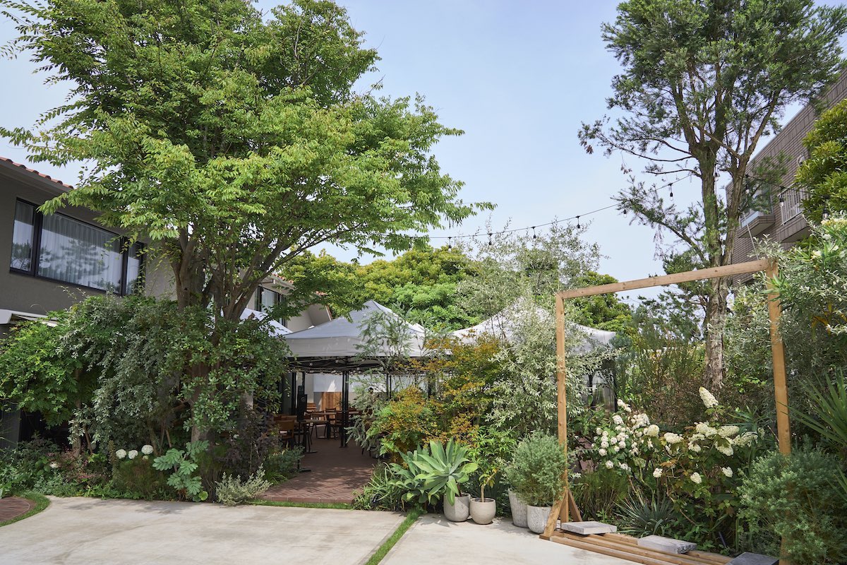 グリーンに囲まれた白いテントの下がテラス席