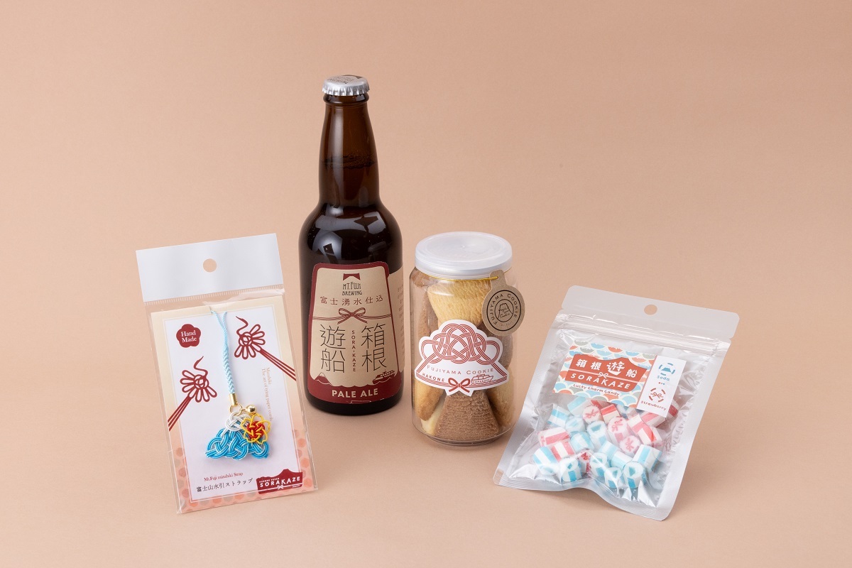 （写真左から順に）「富士山を水引でかたどった根付」880円、「箱根遊船オリジナルクラフトビール」1000円、「ミニフジヤマクッキー（限定パッケージ）」850円、「SORAKAZEオリジナル縁起物キャンディー」650円