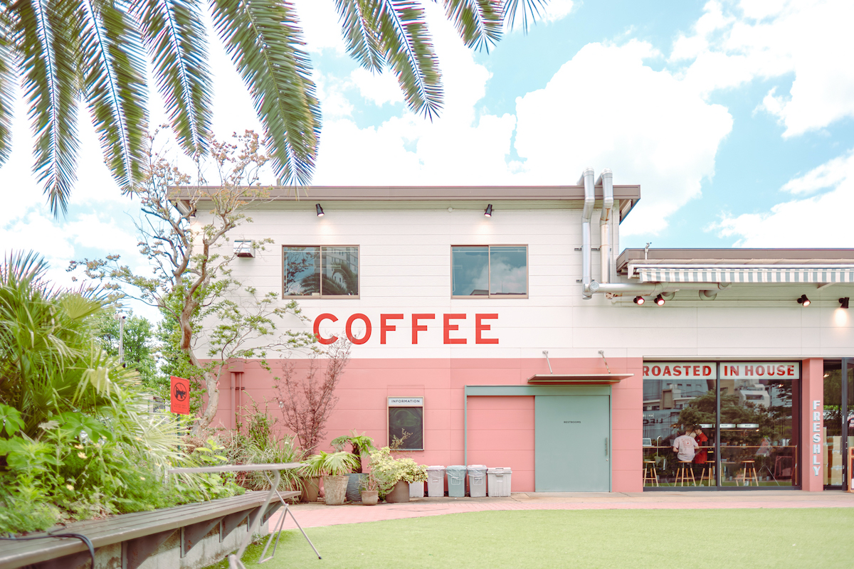 まるで海外の海沿いの街にありそうな外観。広場に広がるグリーンが南国のよう