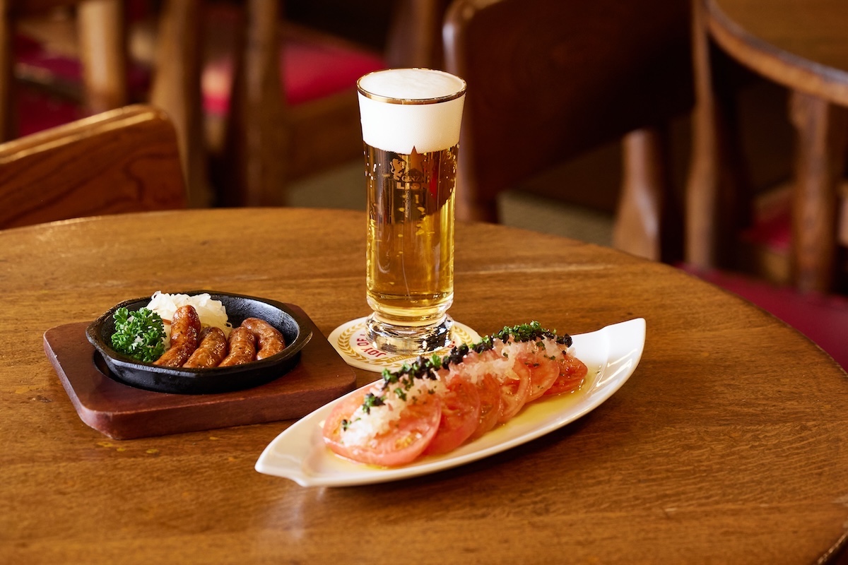 写真奥から時計回りに「一度注ぎ黒ラベル　小グラス(金口)」660円、「トマトのカルパッチョ」750円、「生チョリソーの鉄板焼き」990円