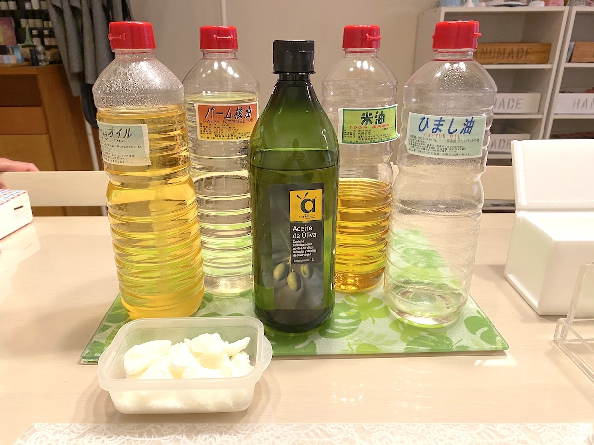 写真手前から反時計回りにムルムルバター、パームオイル、パーム核油、オリーブオイル、米油、ひまし油